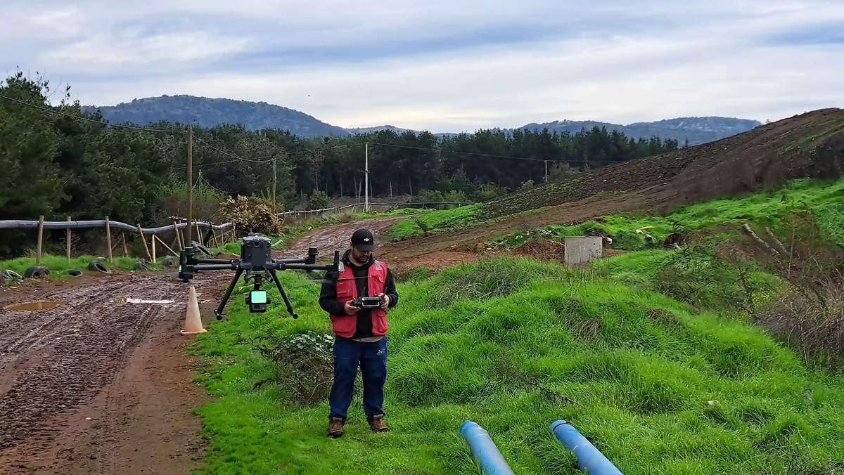 Operador de dron realizando captura aérea en terreno
